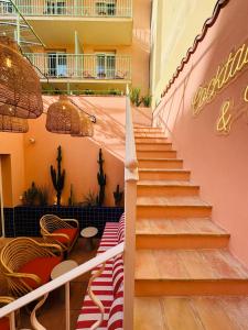 a staircase in a building with red and white chairs at Hôtel Gabriel in Menton