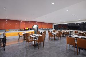 Un comedor con mesas y sillas y un restaurante. en m designer hotel, en Dujiangyan