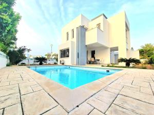 a villa with a swimming pool in front of a house at Luxury Villa Azure in Larnaca