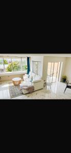 sala de estar con sofá blanco y ventanas en New Kingston Vibes, en Kingston