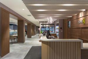 布恩Home2 Suites By Hilton Boone的商店大厅，有柜台和椅子