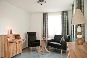 a living room with two chairs and a table at Kapitänshaus in Waabs