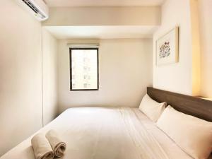 a small bedroom with a bed and a window at Fancy Designed 2BR at Gateway Ahmad Yani Cicadas Apartment By Travelio in Bandung +9 photos