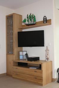 a entertainment center with a flat screen tv on a wall at FeHa Strandmügge in Zingst