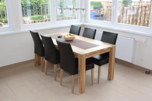 a dining room with a wooden table and black chairs at FeHa Strandmügge in Zingst
