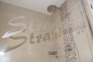 a shower stall with a sign on the wall of a bathroom at FeHa Strandmügge in Zingst +10 photos