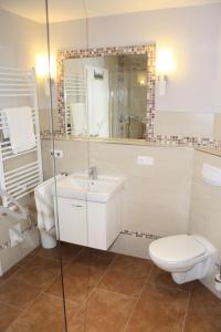 a white bathroom with a toilet and a sink at FeHa Strandmügge in Zingst