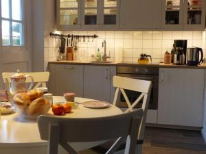 a kitchen with a table with a bowl of fruit on it at Reetkehlchen in Alkersum