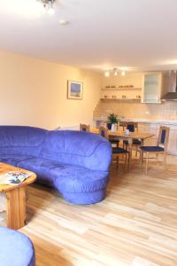 a living room with a blue couch and a table at "Hof Triangel - Whg 3" - Bauernhofurlaub in Riepsdorf