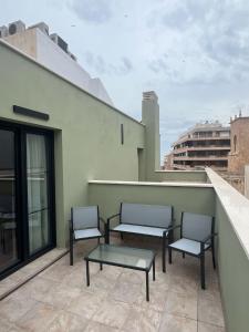 two chairs and a table on a balcony at Apartamentos La Basílica by BeAlicante in Alicante