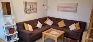a living room with a brown couch with yellow pillows at Ferienhäuschen Neuberend in Neuberend