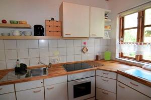 a kitchen with white cabinets and a wooden counter top at Ferienhäuschen Neuberend in Neuberend