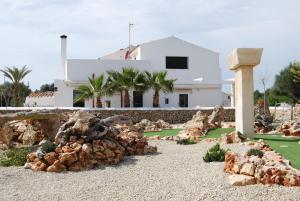 Uma casa com um monte de pedras à frente. em Turismo Rural Biniati des Pi em Sant Lluis