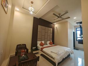 a bedroom with a bed and a ceiling fan at Hotel Pink City in Sīkar +70 photos