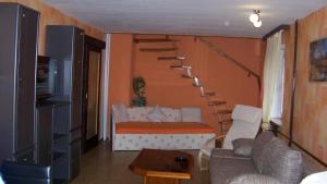a living room with a couch and a spiral staircase at Ferienwohnung in Waldidylle