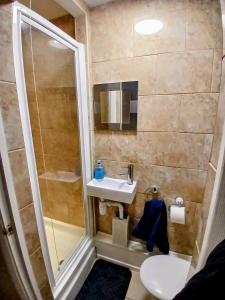 a small bathroom with a sink and a shower at Ipswich Town 3 Bed House in Copdock