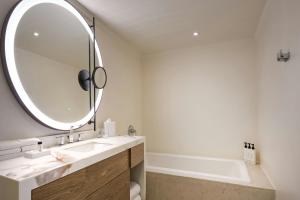 a bathroom with a sink and a large mirror at Treasure Beach Art Hotel, An Autograph Collection All-Inclusive Resort in Saint James +18 photos