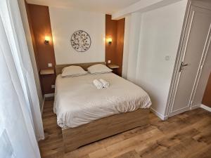 a bedroom with a bed with two towels on it at Maisonette Cozy, Neuf, Centre-ville, Wifi in Elbeuf