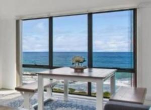 a room with a table with a view of the ocean at 15 Whitecrest Great Ocean Road Resort - Ocean View in Apollo Bay