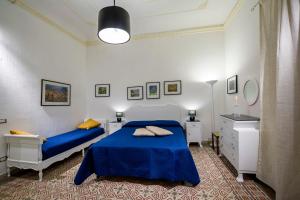 sypialnia z niebieskim łóżkiem i komodą w obiekcie Le Case di Katy w mieście Castellammare del Golfo