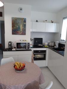 eine Küche mit einem Tisch mit einer Obstschale darauf in der Unterkunft Orée du Parc in Royan