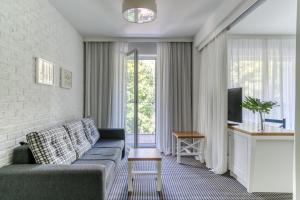 uma sala de estar com um sofá e uma TV em Hotel Shuum Boutique - Destigo Hotels em Colberga