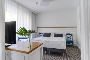 um quarto com uma cama e uma escrivaninha com uma TV em Hotel Shuum Boutique - Destigo Hotels em Colberga mais 174 fotografias