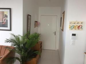 einen Flur mit einer Pflanze und einer weißen Tür in der Unterkunft Orée du Parc in Royan