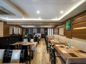 a dining room with wooden tables and chairs at Hotel City Tower, Chennai Central in Chennai