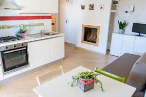 cocina y sala de estar con mesa y fogones en Appartamento Villa Nisapiro' Sannicola, en Sannicola 163 fotos más