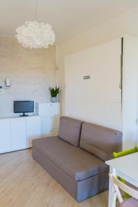 Una sala de estar con un sofá y un televisor. en Appartamento Villa Nisapiro' Sannicola, en Sannicola