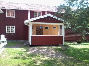 ein rotes Haus mit Garage in der Unterkunft Dränggårdens Stuga på Genuin Rättviksgård in Boda