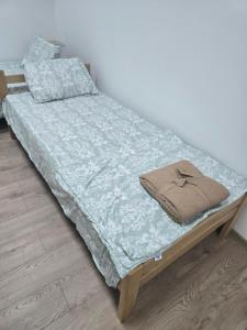 a bed with a blue comforter on top of it at Smestaj za radnike Stadion Lagator Loznica in Loznica
