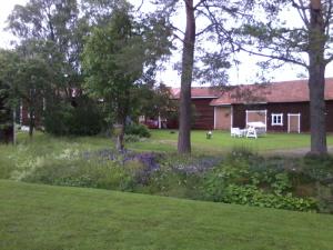 a garden with purple flowers and a house at Dränggårdens Stuga på Genuin Rättviksgård in Boda