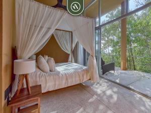a bedroom with a canopy bed with a window at Luxury Oceanfront Villa - Private Pool -Temazacal in Chamela +79 photos