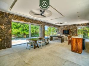 a dining room with a table and a stone wall at Luxury Oceanfront Villa - Private Pool -Temazacal in Chamela