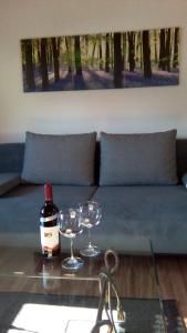 a table with two glasses and a bottle of wine at Ferienwohnung Klein am Natursteig Sieg in Bitzen