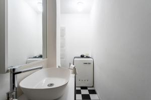 Un baño blanco con lavabo y espejo. en Orcagna Apartment, en Florencia 22 fotos más