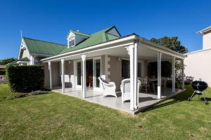 a screened in porch of a house with a grill at 4188 River Club in Plettenberg Bay