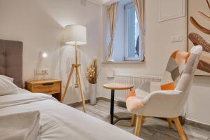 ザグレブにあるApartments Old Town Gloriaのベッドと椅子とテーブルのある寝室