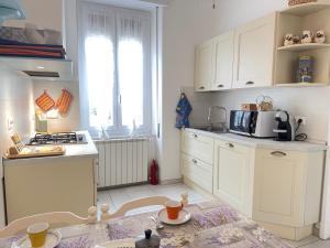 a kitchen with white cabinets and a stove top oven at 1 Min Walk from the Sea, with 2 Bed and 2 Bath in Alassio