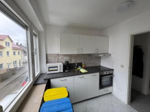 a small kitchen with white cabinets and a window at WatzMannOG in Augsburg