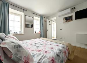 a bedroom with a bed with a floral bedspread at Stanza Allegra Soave in Soave