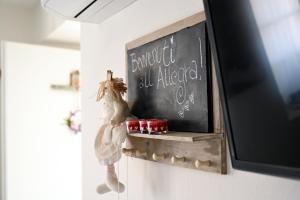 a chalkboard with a chicken on a shelf next to a tv at Stanza Allegra Soave in Soave