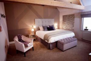a bedroom with a large bed and a chair at The Tickled Trout in Maidstone