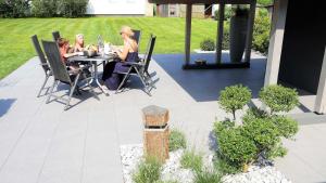 two women sitting at a table on a patio at Ferienhaus Modi in Eckernförde