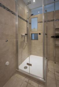una ducha con puerta de cristal en un baño en Ferienwohnung Bania, en Lindau-Bodolz