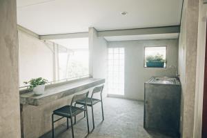 a kitchen with two chairs and a counter with a sink at Koja CoLiving in Bandung