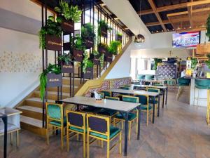 a restaurant with tables and chairs and plants at HOTEL GOLDEN CARTAGO in Cartago