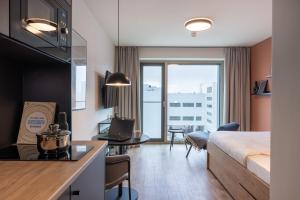 a hotel room with a bed and a desk with a laptop at The Base Munich in Munich +45 photos